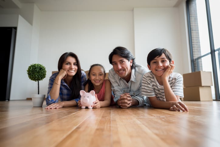 Smooth Move Moving Services in South Carolina | family saving money for new house, sitting on hardwood floor with piggy bank